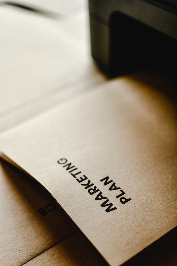 Services-02 Detailed view of the words Marketing Plan printed on brown paper, conceptual and business themed.